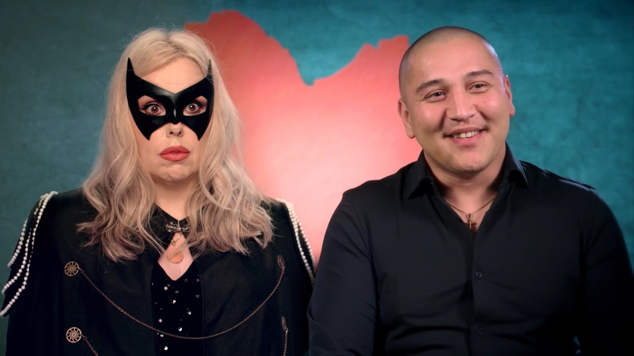 A couple on a reality-dating-show set, one wearing a black cat mask